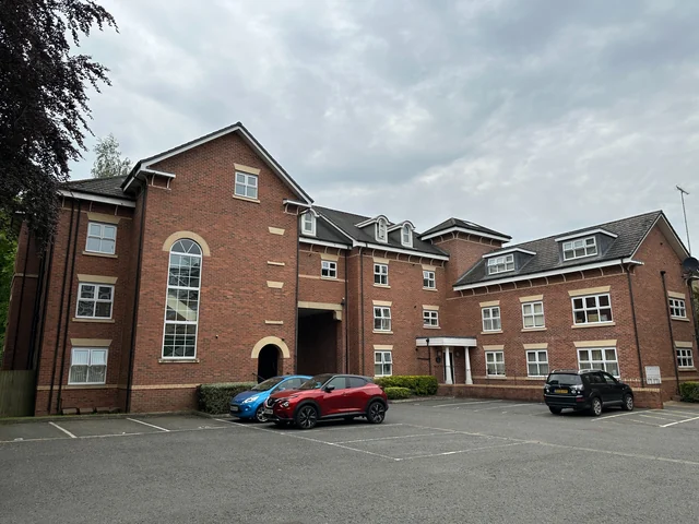 Brick apartment building overlooking a parking courtyard in Sale