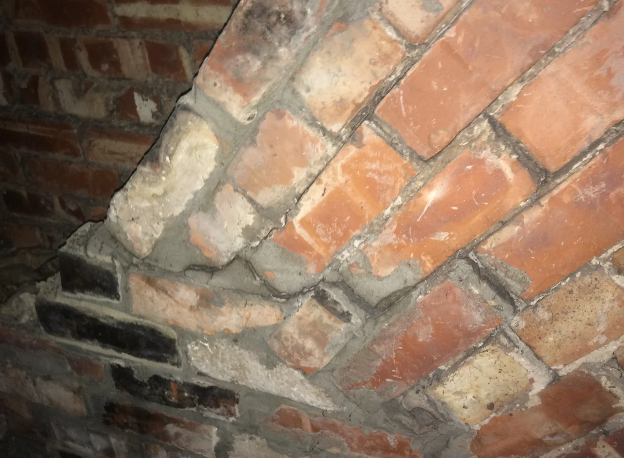 Open cracks through the mortar joints of retained chimney masonry in the roof space in Cheadle Hulme