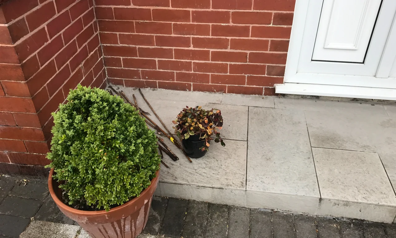 Raised tiled entrance step abutting the lower brickwork beneath the front door in Sale